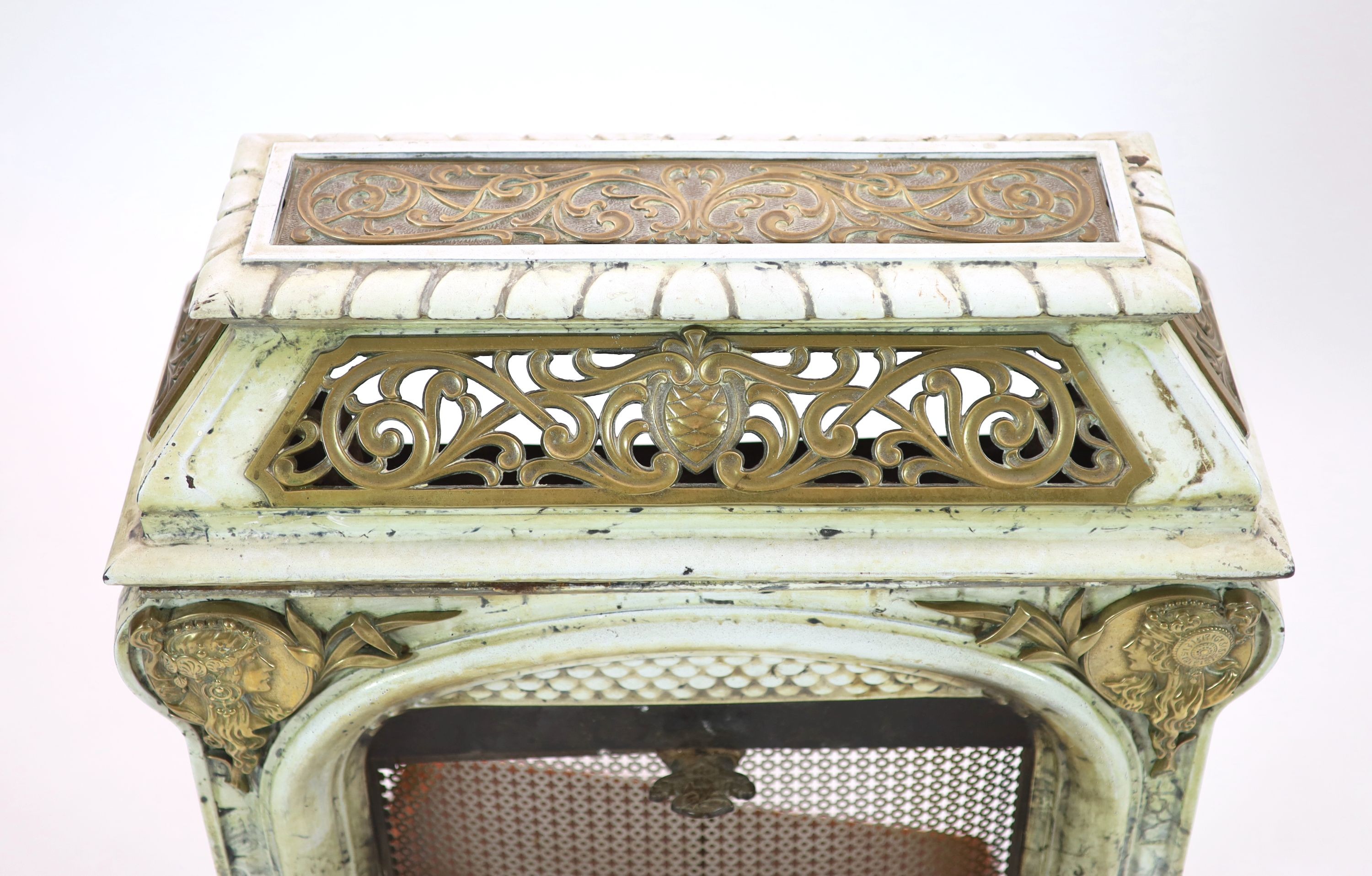 A late 19th century French Art Nouveau enamelled cast iron and brass fire surround H 91cm. W 82cm. D 46cm.